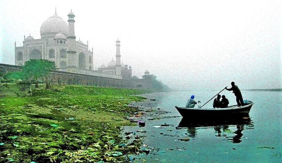 BOATMAN ROWS HIS BOAT ON A COLD AND FOGGY MORNING IN AGRA